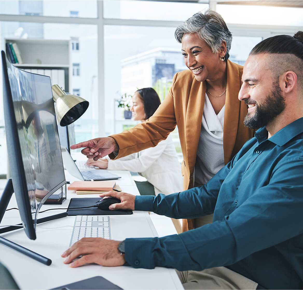 Two people working infront of the computer.